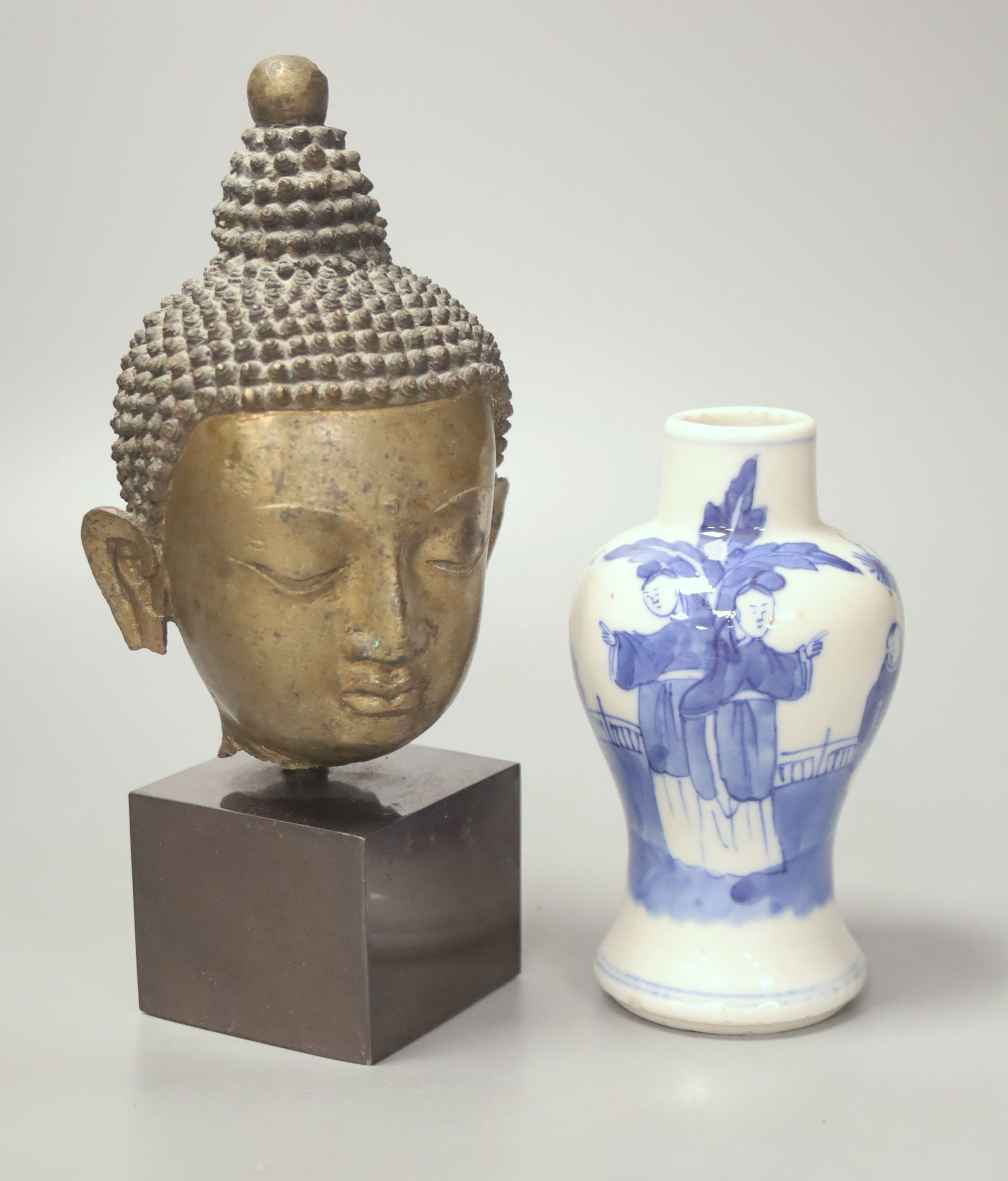 A Thai or Burmese bronze Buddha’s head, with stand 20.5cm and a 19th century Chinese blue and white vase, 12.5cm